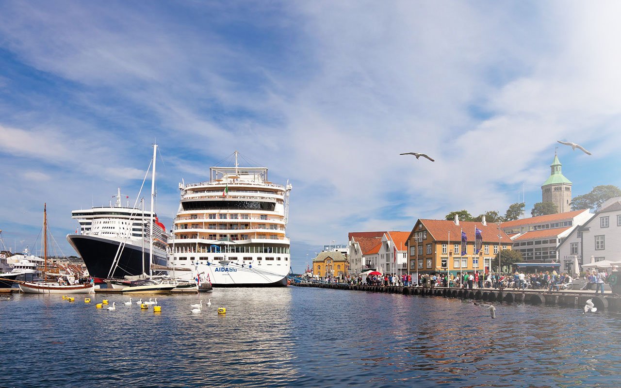 Bilde av Skagenkaien i Stavanger, to store cruiseskip ligger til kai og mange mennesker er på bryggen.