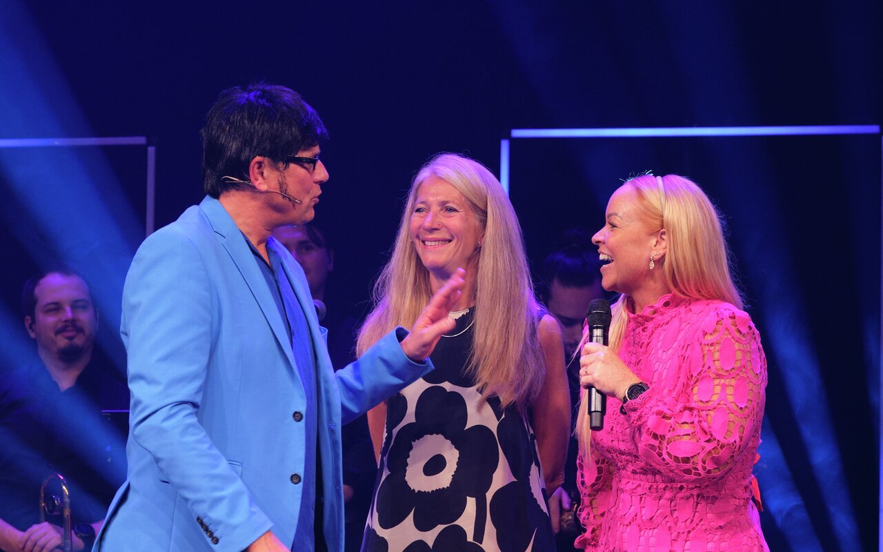 Bente Sofie Vraalsen (t.h.) fikk prisen av Ingebjørg Harto, styreleder i Regnskap Norge, mens komiker Robert Stoltenberg underholdt på Overskudd 2025. Foto: Regnskap Norge